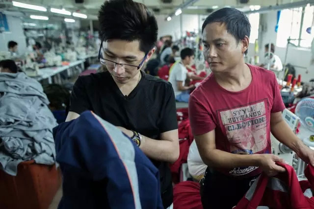 在布料工厂里，李宏辉监督自己的布料生产